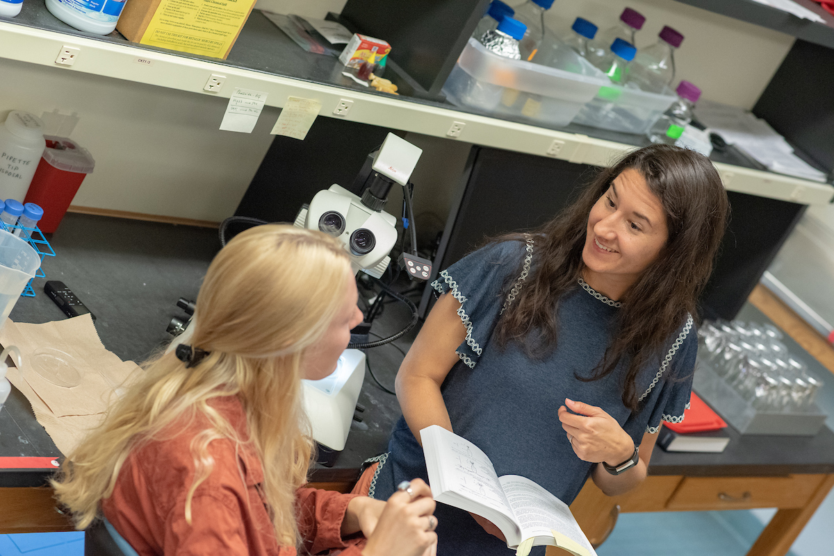 Two individuals having conversation in a biology lab