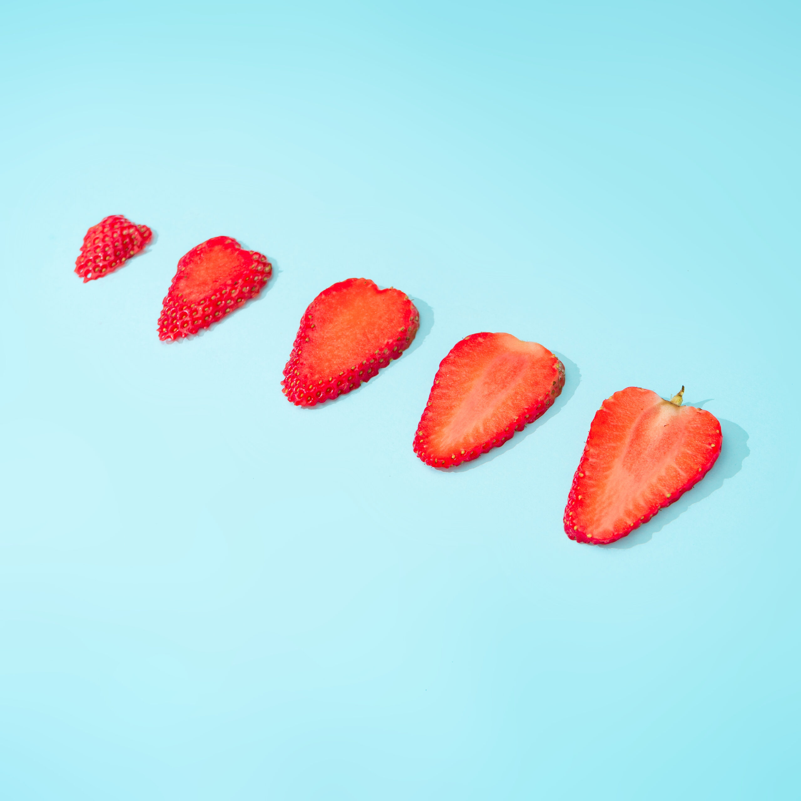 Creative summer background composition with strawberry slices.  Minimal fruit concept