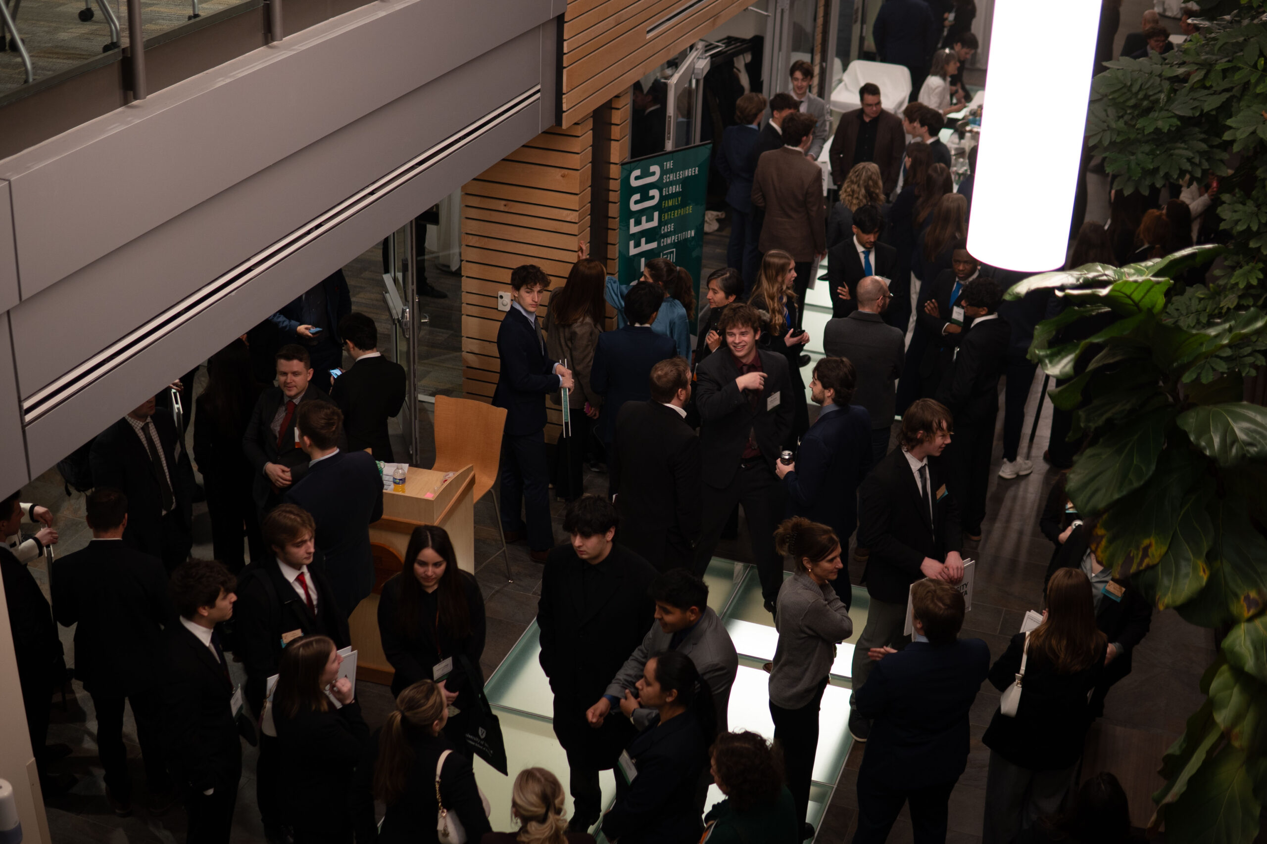 Students, coaches, and judges mingle in business suits in Ifshin Hall.