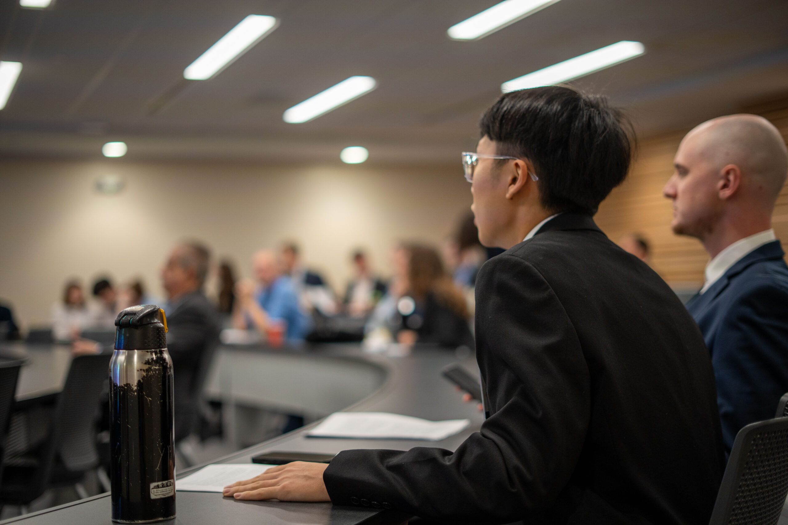 students in business attire listen intently as instructions are given